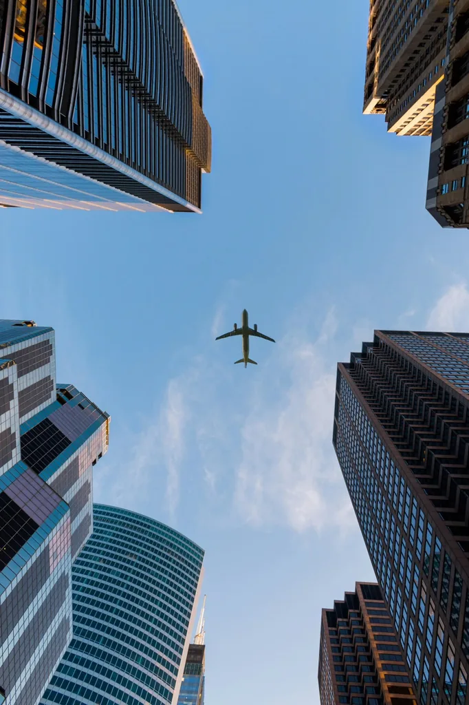 A plane flying over city skyscrapers